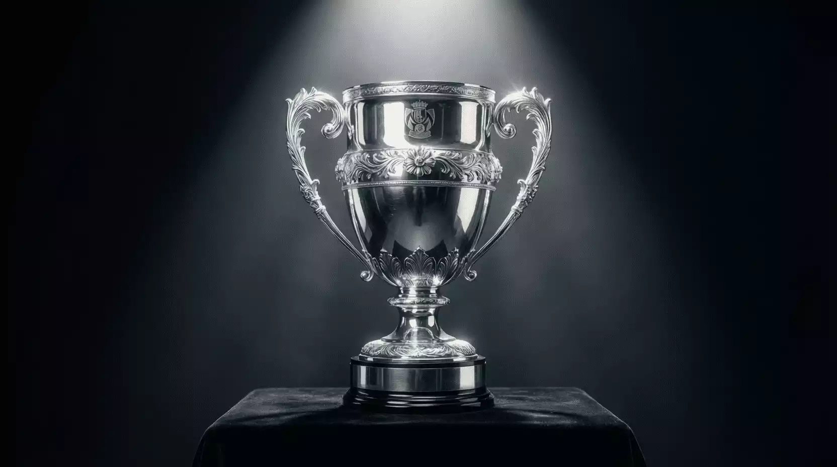 Trofeo de la Copa del Rey sobre un pedestal con iluminación dramática